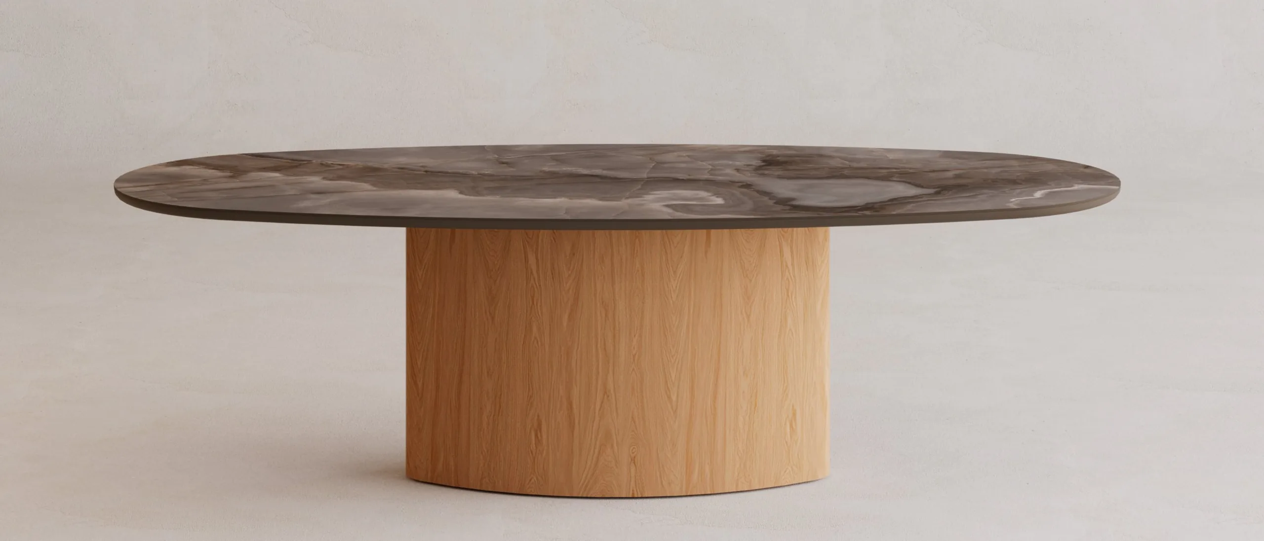 Stół Elisse z kolekcji Organica Vena Design: owalny blat ze spieku kwarcowego Reve Choco w wykończeniu mat na eliptycznej podstawie z forniru dębowego, ujęcie z przodu na tle jasnego tynku.
